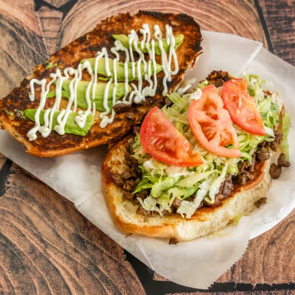 El Güero Canelo's Mexican torta with carne asada, lettuce, tomato, avocado, and crema on toasted bread.